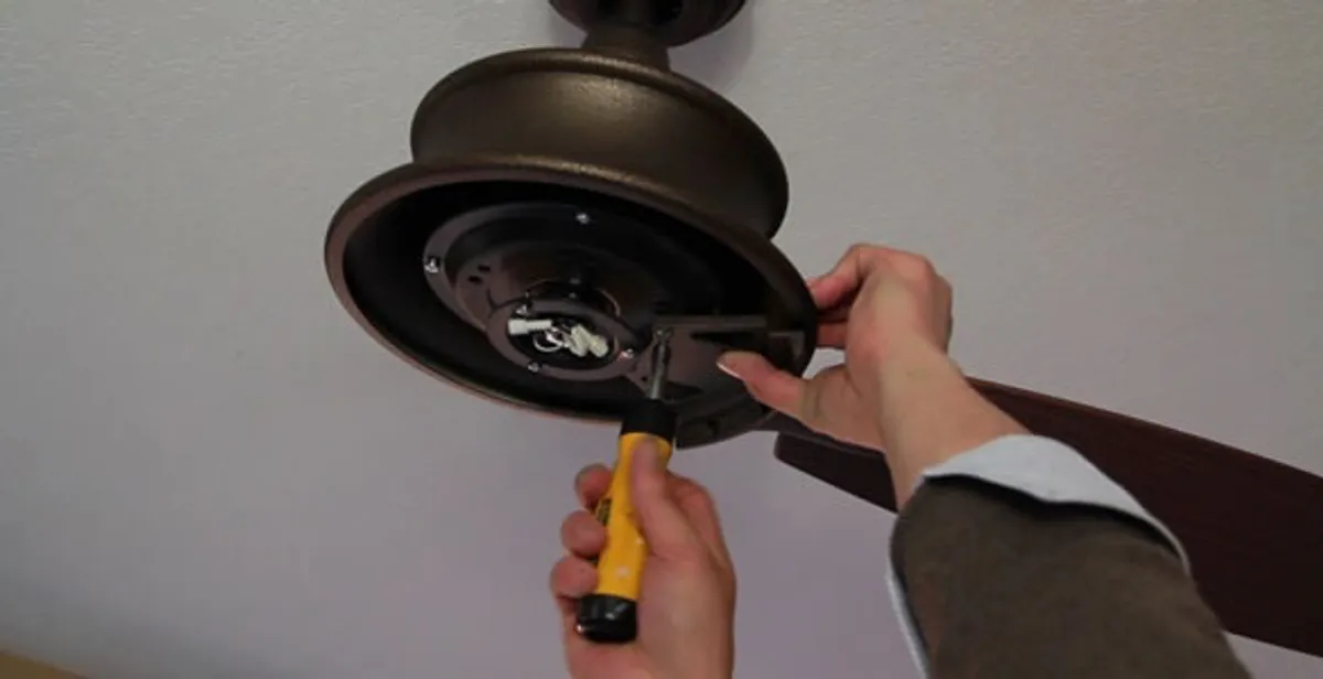 Electrician installing ceiling fan mounting bracket and fixture in Glendale, AZ