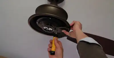 Electrician installing ceiling fan mounting bracket and fixture in Glendale, AZ