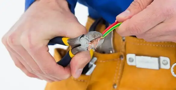 licensed electrician securing electrical wiring with professional tools during service work in Glendale, AZ