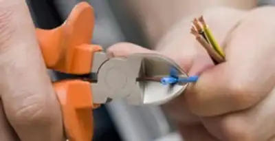 licensed electrician performing precise wire cutting and preparation during electrical service in Glendale, AZ