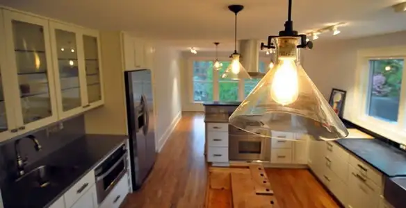 Residential electrician installing modern indoor light fixture in a home in Glendale, AZ