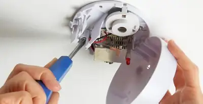 Certified technician wiring smoke detector during installation in Glendale, AZ